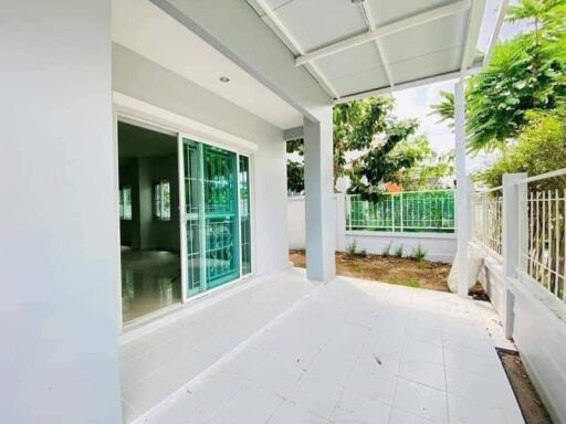 Spacious and bright porch area with white tiles and green window frames