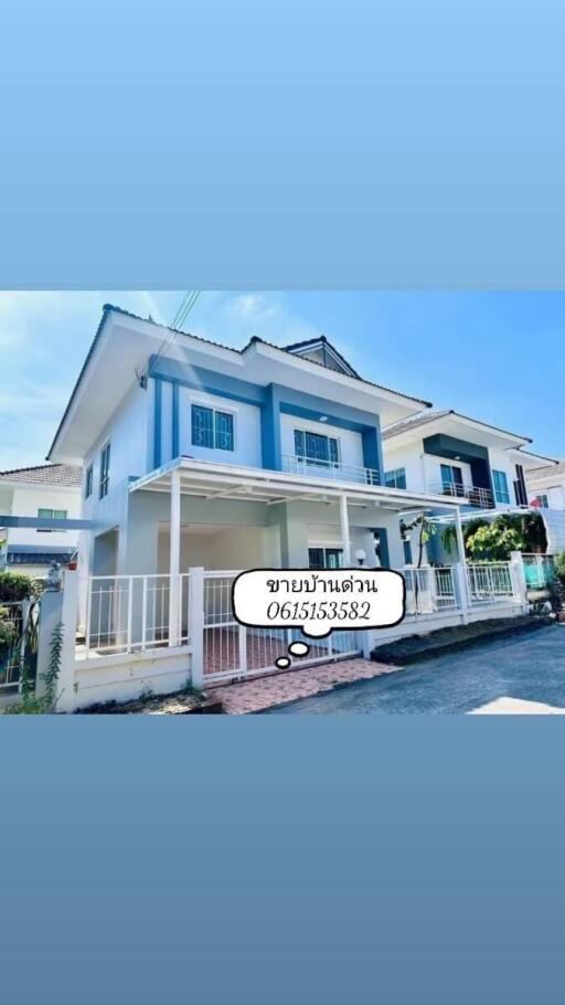 Exterior view of a modern two-story house with blue and white facade