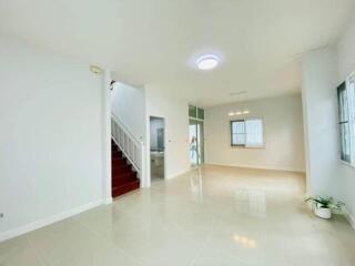 Spacious and bright living room with staircase and glossy tiled flooring