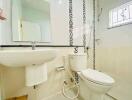 Modern bathroom with white ceramic fixtures and decorative mosaic tiles