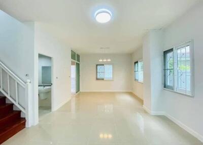 Spacious and well-lit living room with glossy tiled flooring