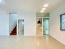 Spacious and bright living room with staircase and modern kitchen view