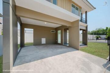 Spacious carport area adjacent to residential building with partial view of backyard
