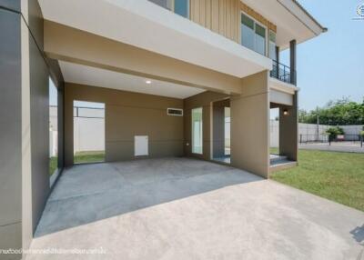 Spacious carport area adjacent to residential building with partial view of backyard