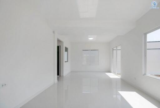 Spacious and bright empty room with large windows and glossy white floors
