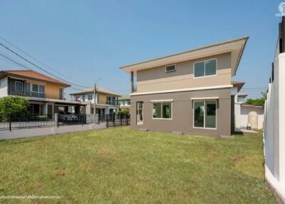 Spacious backyard of a modern two-story home with well-maintained lawn