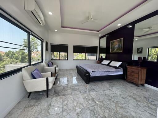 Spacious bedroom with modern furniture and large windows