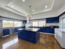 Spacious modern kitchen with blue cabinets and hardwood floors