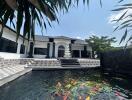 Luxurious home exterior with koi pond and steps leading to a grand entrance