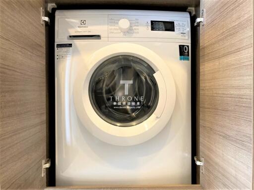Modern built-in washing machine in a compact laundry room cabinet