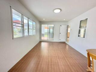 Spacious and well-lit living room with large windows and access to balcony