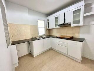 Spacious modern kitchen with white cabinets and tiled backsplash