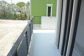 Spacious balcony with green wall view and safety railing