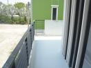 Spacious balcony with green wall view and safety railing