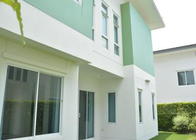 Exterior view of a modern two-story house with green and white walls