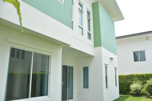 Exterior view of a modern two-story house with green and white walls