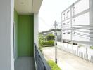 Bright and spacious balcony with green wall and urban view