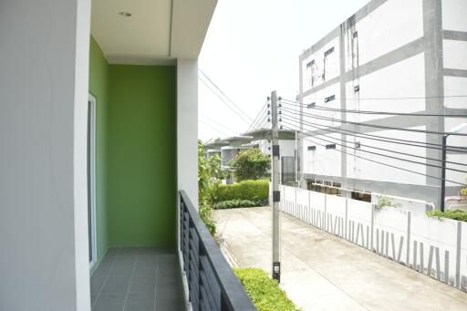 Bright and spacious balcony with green wall and urban view