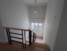 Bright staircase area with wooden steps and modern railing