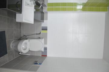 Modern bathroom design with clean white tiles and equipped with sanitary fixtures