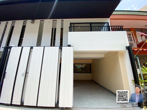 Modern two-story house with a bold black and white facade and secure front gate