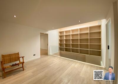 Spacious living room with large shelving unit and hardwood floors