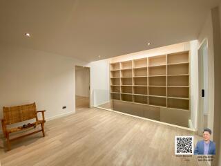 Spacious living room with large shelving unit and hardwood floors