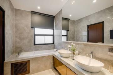 Modern bathroom with dual sinks and large bathtub