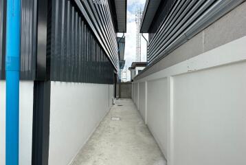 Narrow exterior passage between industrial style buildings