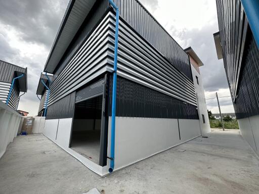 Exterior view of a modern industrial warehouse with distinctive blue and white design