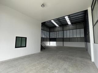 Spacious industrial warehouse with high ceiling and large windows