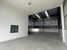 Spacious industrial warehouse with high ceiling and large windows