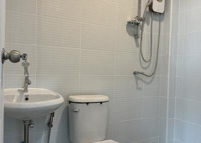 Modern bathroom with white fixtures and wall-mounted shower unit