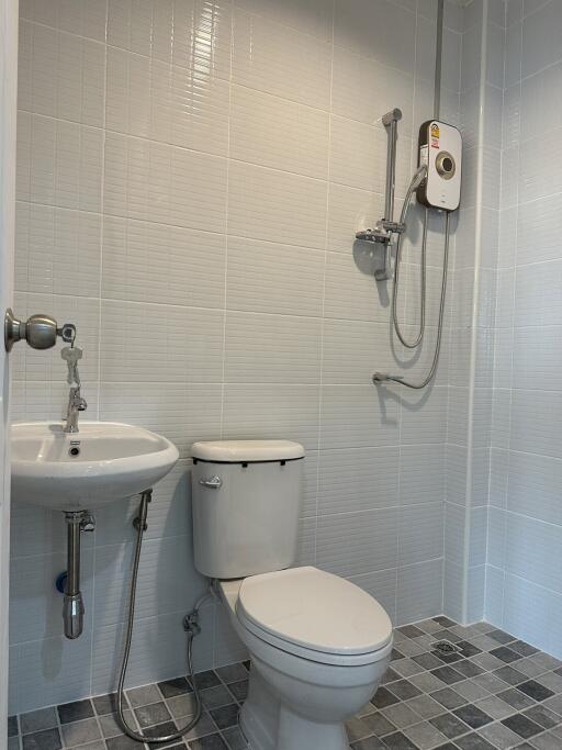 Modern bathroom with white fixtures and wall-mounted shower unit