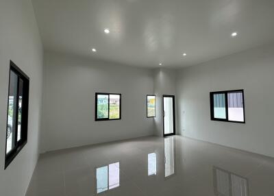 Spacious and bright modern living room with large windows and glossy tiled floor