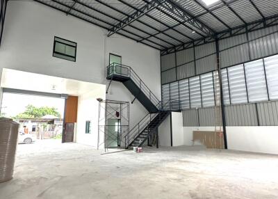 Spacious industrial building with large open area, mezzanine floor, and staircase