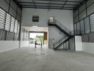 Spacious industrial warehouse interior with high ceiling and multiple storage levels