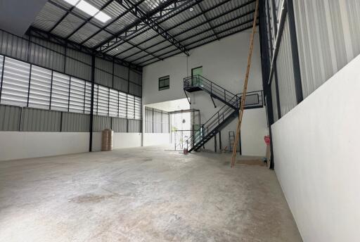 Spacious industrial warehouse interior with mezzanine and large open area