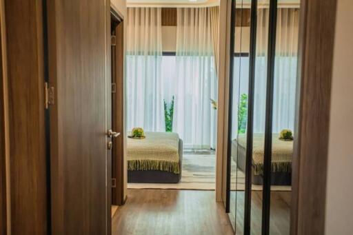 Elegant bedroom with mirrored wardrobe doors and view into garden