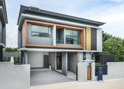 Modern two-story house with stylish grey and wood facade