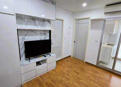 Modern living room with white entertainment unit and wooden flooring