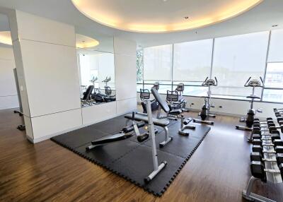 Modern fitness center with large windows and various equipment