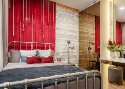 Elegant bedroom with red accent wall and modern decor