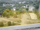 Aerial view of a vacant land plot outlined in yellow near urban area