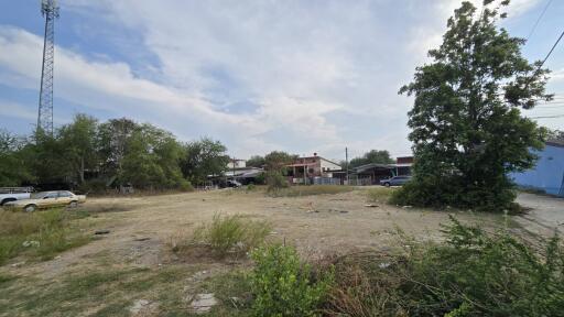 Urban vacant lot with scattered debris and surrounding buildings