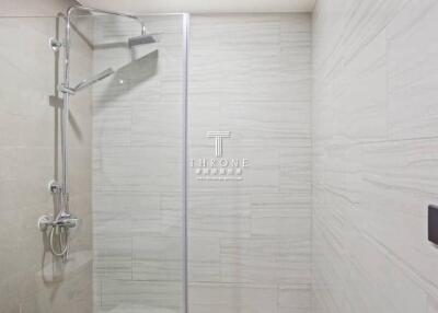 Modern bathroom with glass shower door and elegant tiling