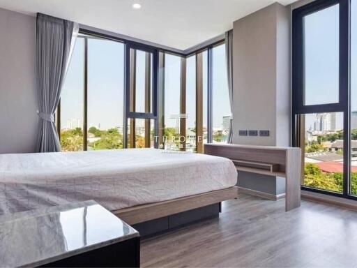 Spacious modern bedroom with large windows and city view