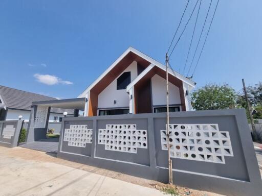 modern house exterior with decorative fence and clear blue sky