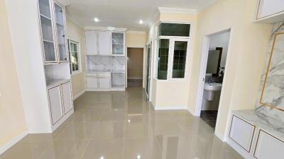 Spacious modern kitchen with white cabinetry and marble flooring