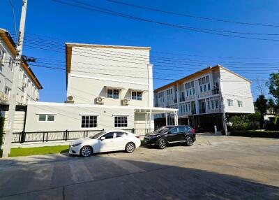 Modern residential apartment buildings with parking lot under clear blue sky